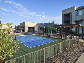 a tennis court is in the middle of a house with a fence